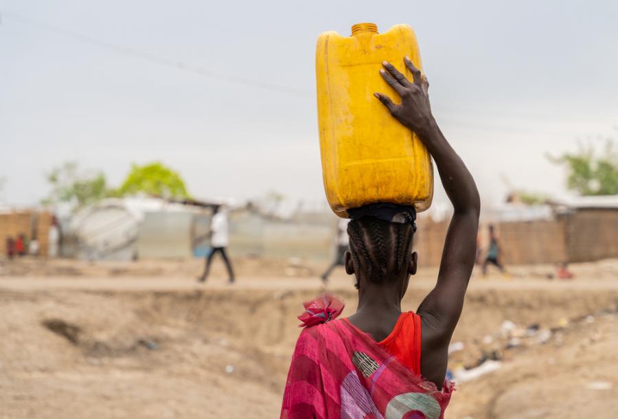 A woman with her children living in the wood shelter in Bentiu