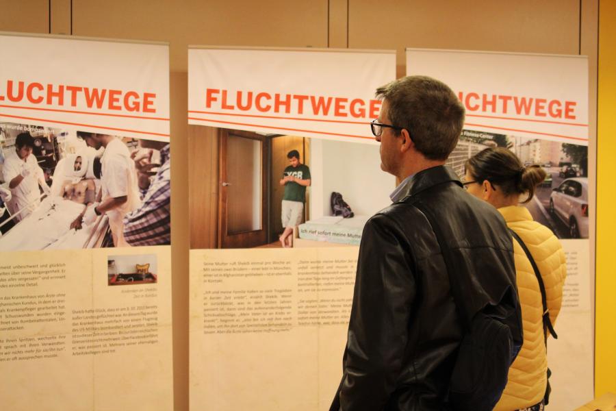 BesucherInnen sehen sich die Ausstellung Fluchtwege von Ärzte ohne Grenzen an.