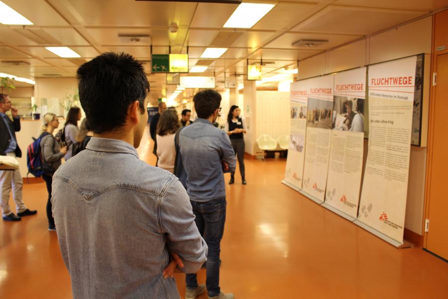 BesucherInnen sehen sich die Ausstellung Fluchtwege von Ärzte ohne Grenzen an.