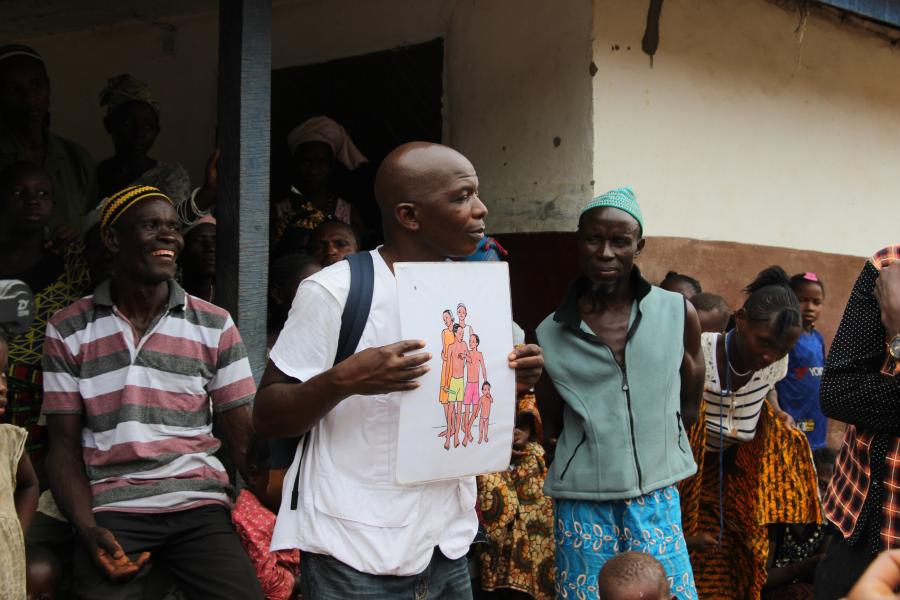 Kenema, Sierra Leone, März 2019: Im Dorf Bondayilahun klärt Gesundheitsberater Tamba Magnus Aruna mit Schautafeln über Gesundheitsprävention auf.