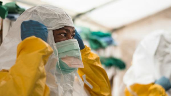 Bevor die medizinischen Teams im Isolationsbereich Ebola-PatientInnen versorgen können, muss die entsprechende Schutzkleidung angelegt werden.