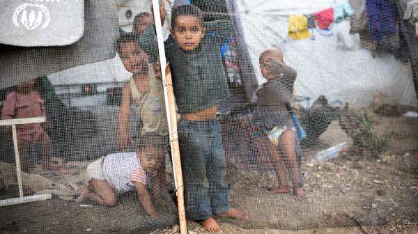 Kleine Kinder im Flüchtlingscamp Moria hinter einem Zaun.