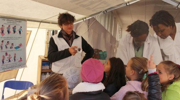 Krankenpfleger Florian Blaser führt eine Schulklasse durch die Ausstellung „Hilfe aus nächster Nähe“